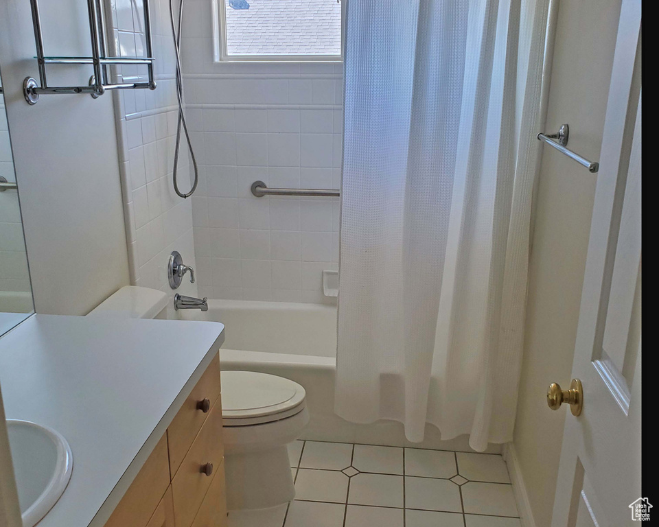 Full bathroom featuring tile patterned flooring, shower / bath combination with curtain, toilet, and vanity