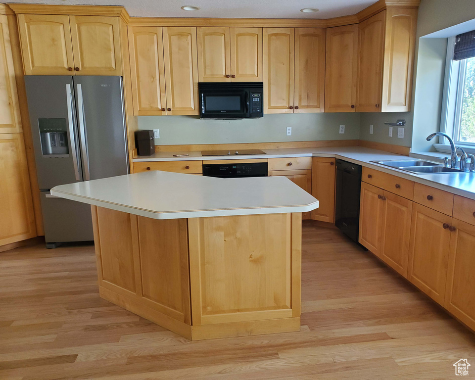 Kitchen with black appliances, light brown cabinets, and a sink