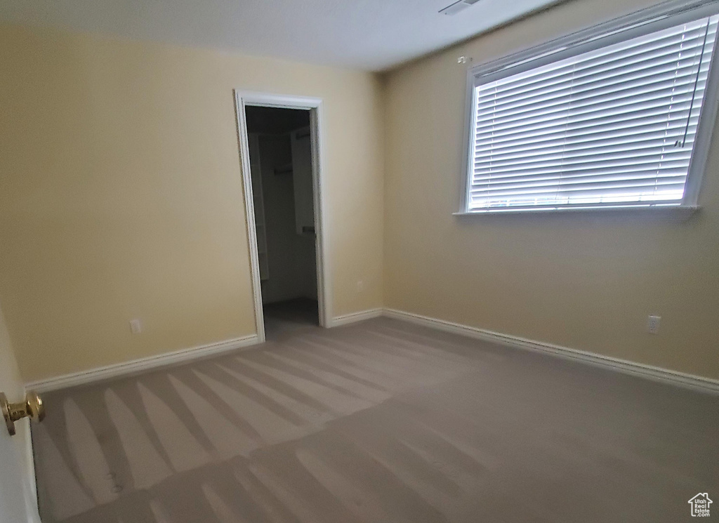 Spare room featuring carpet flooring and baseboards