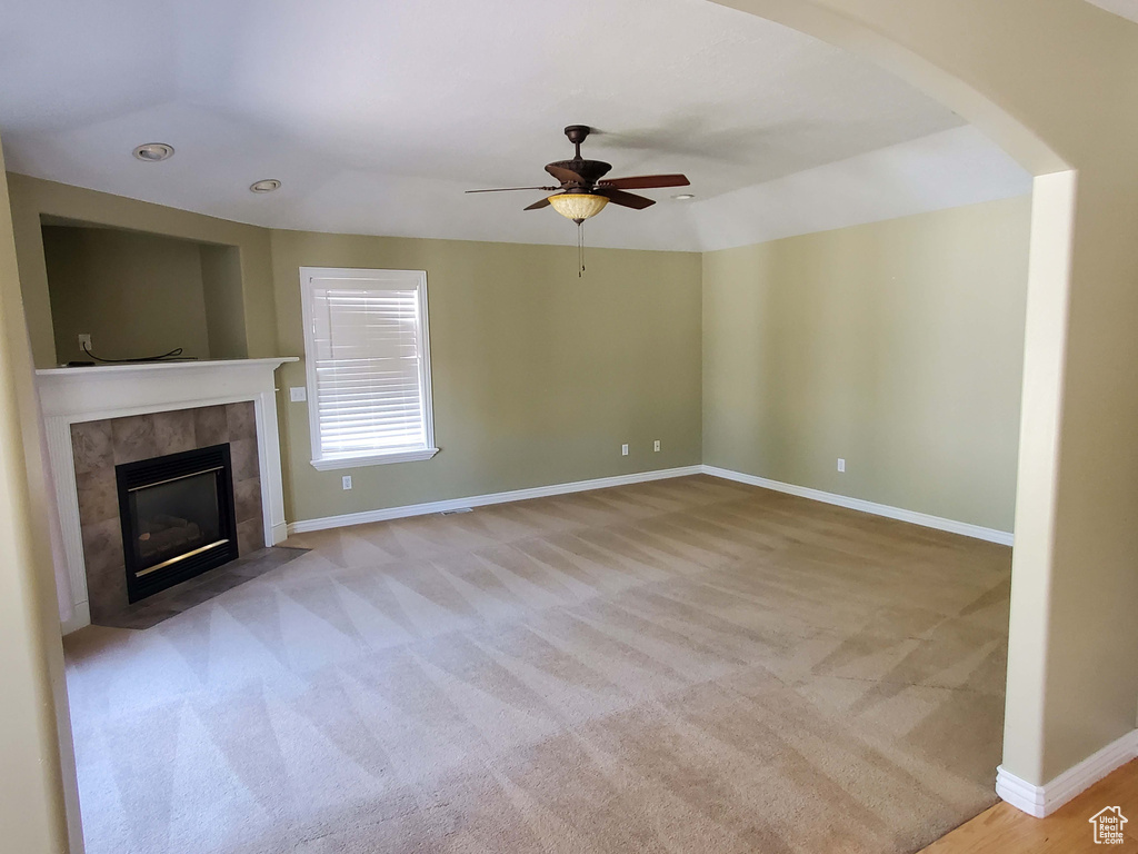 Unfurnished living room featuring baseboards, light carpet, recessed lighting, a tile fireplace, and a ceiling fan