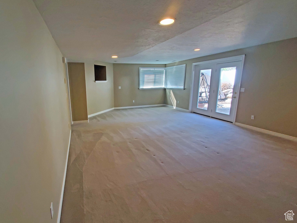 Unfurnished room with recessed lighting, light colored carpet, baseboards, and a wealth of natural light