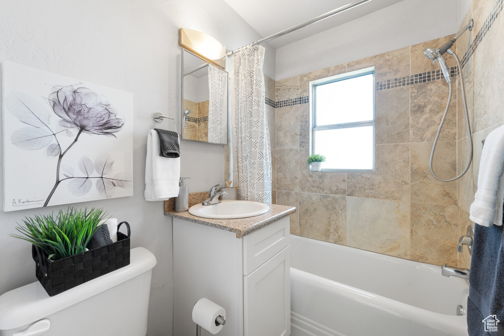 Bathroom with vanity, toilet, and shower / tub combo
