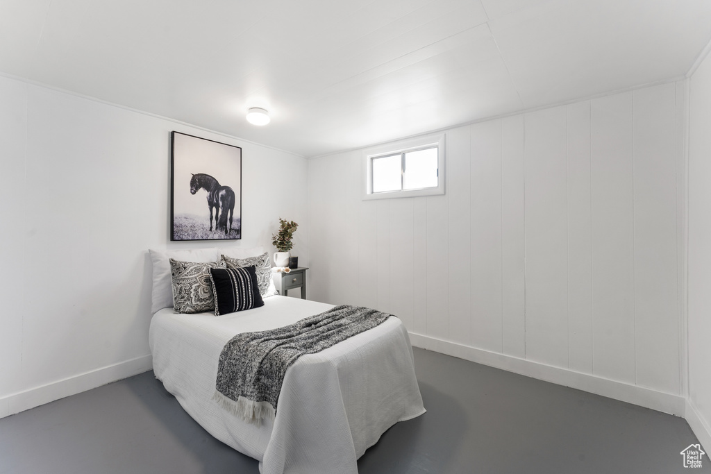 Bedroom featuring baseboards and finished concrete floors