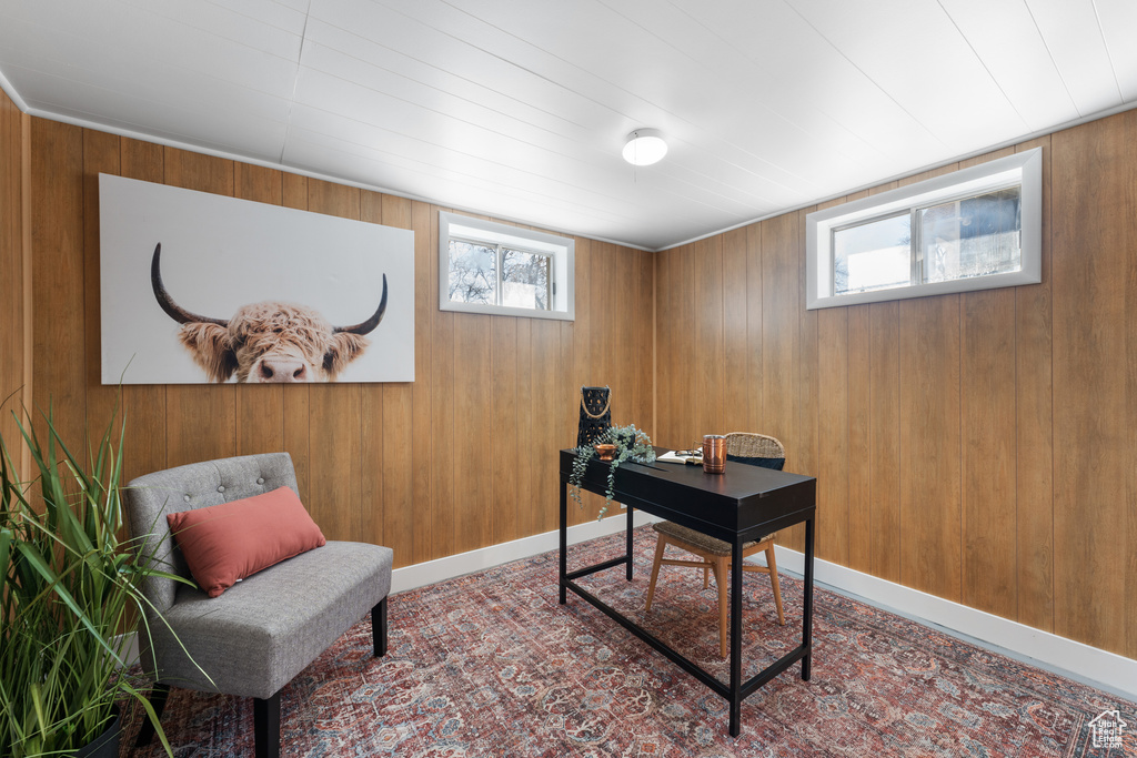 Home office featuring baseboards and wooden walls