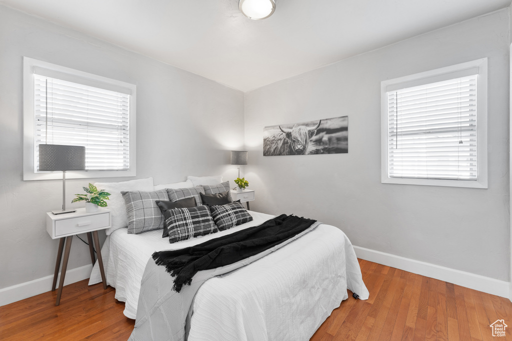 Bedroom featuring multiple windows, wood finished floors, and baseboards