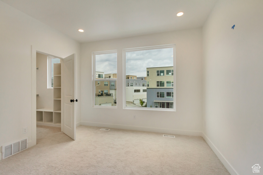 Unfurnished room with carpet floors, visible vents, and baseboards