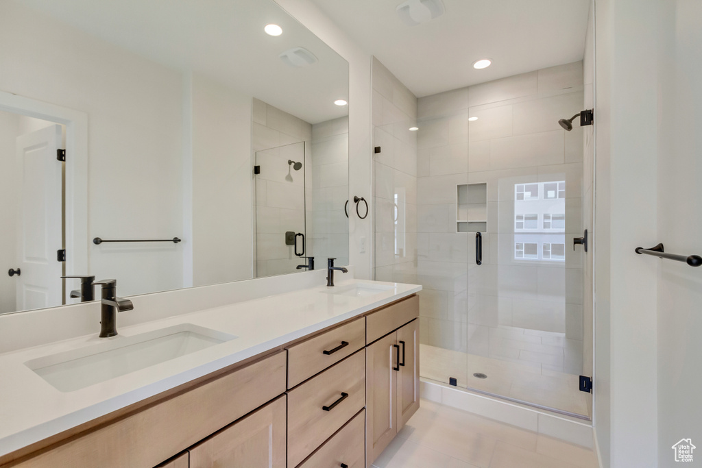 Full bathroom with a sink, recessed lighting, double vanity, and a stall shower
