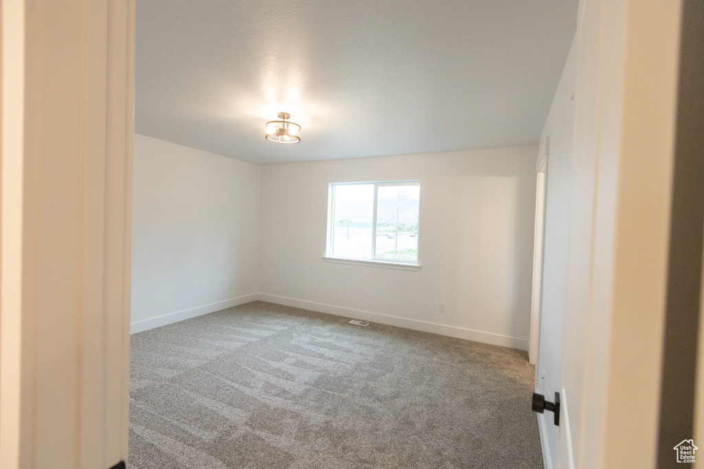 Spare room featuring baseboards and carpet