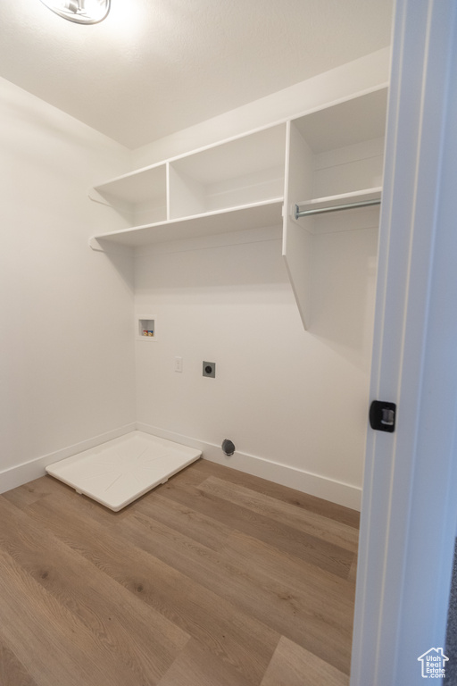 Laundry room featuring washer hookup, wood finished floors, baseboards, hookup for an electric dryer, and laundry area