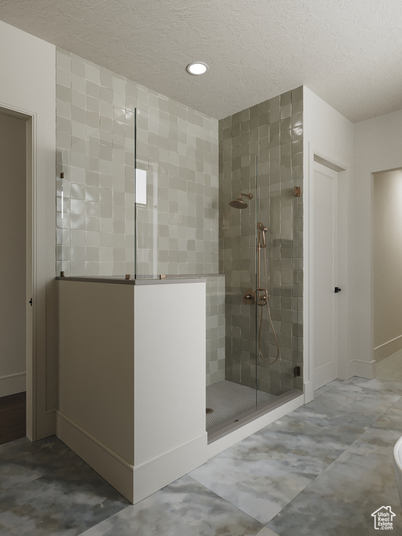 Bathroom featuring a stall shower, a textured ceiling, and recessed lighting