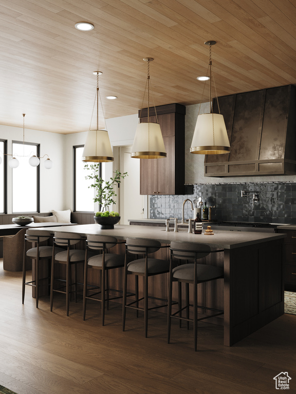 Kitchen featuring dark wood-style flooring, tasteful backsplash, a breakfast bar, wooden ceiling, and recessed lighting