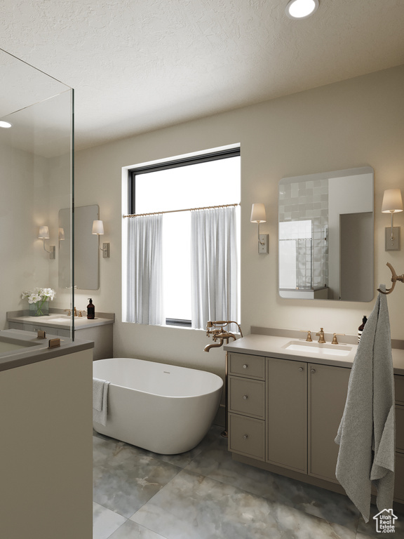 Bathroom featuring a freestanding bath, vanity, and a textured ceiling