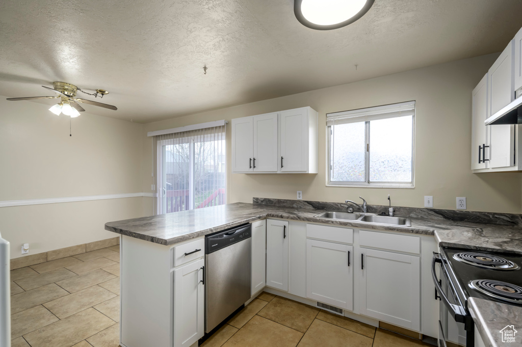 Kitchen featuring a sink, dishwasher, a peninsula, and white cabinets