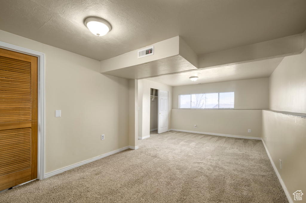 Unfurnished bedroom featuring visible vents, carpet floors, a textured ceiling, and baseboards