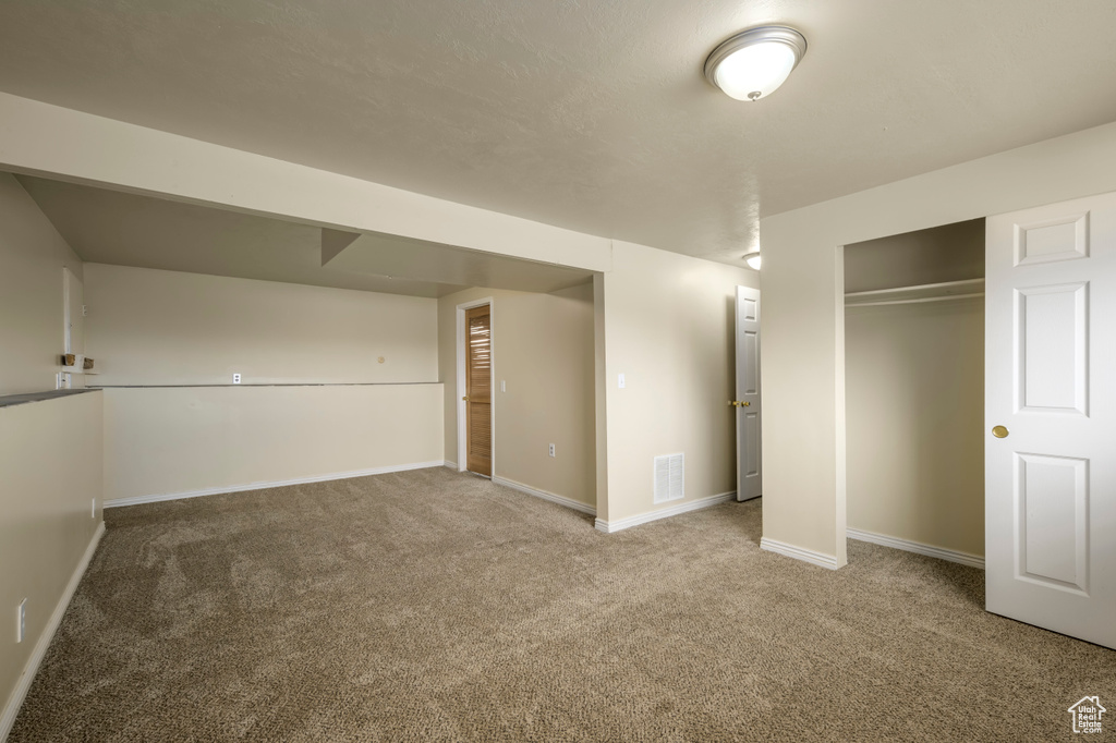 Below grade area with visible vents, baseboards, and carpet flooring