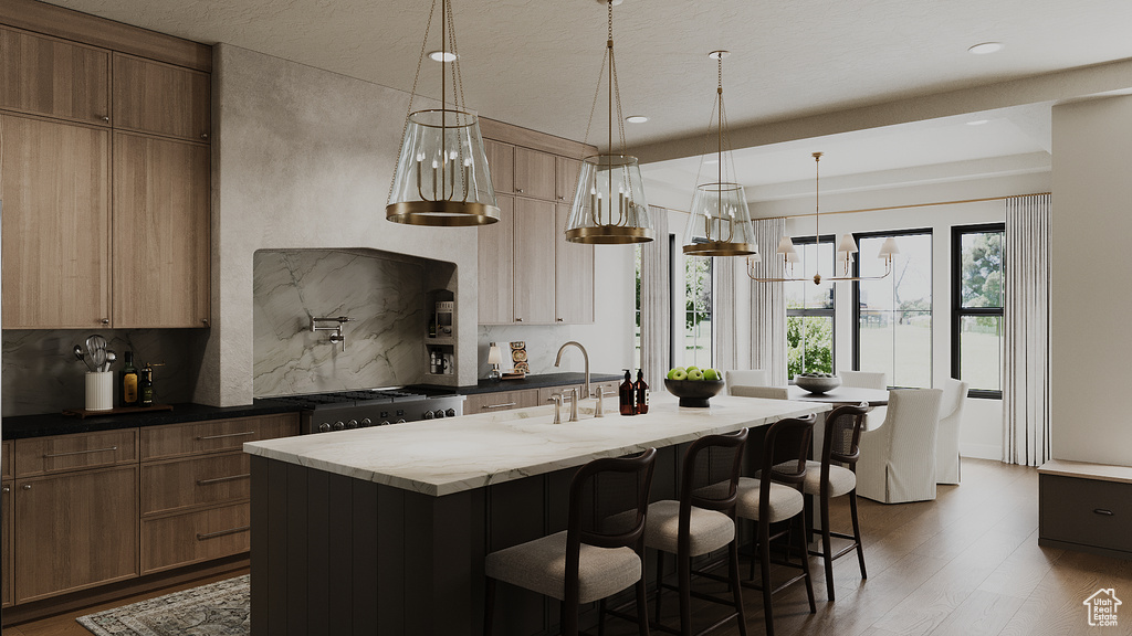 Kitchen featuring a center island with sink, backsplash, dark wood-style floors, a kitchen bar, and recessed lighting