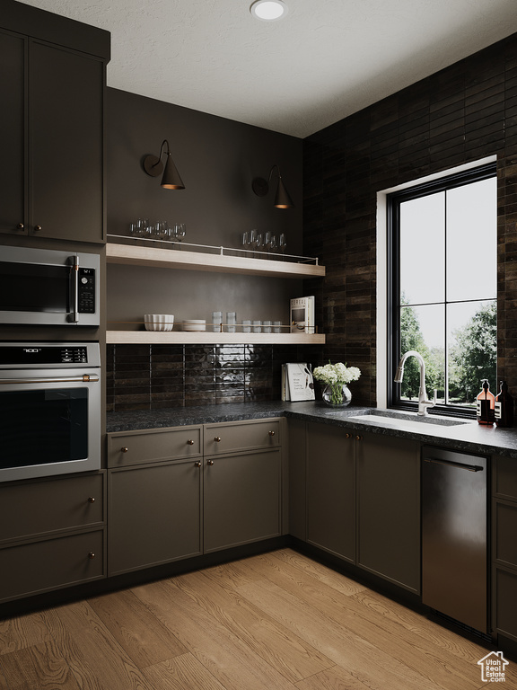 Kitchen with stainless steel appliances, open shelves, and light wood-style floors