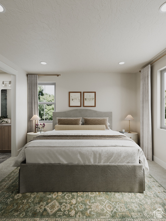 Carpeted bedroom featuring a textured ceiling, recessed lighting, and ensuite bathroom