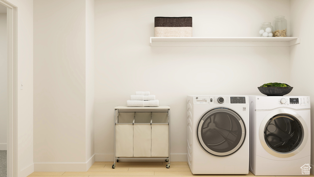 Laundry area with laundry area, light wood-style flooring, baseboards, and independent washer and dryer