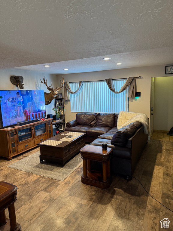 Living area with recessed lighting, a textured ceiling, and hardwood / wood-style floors