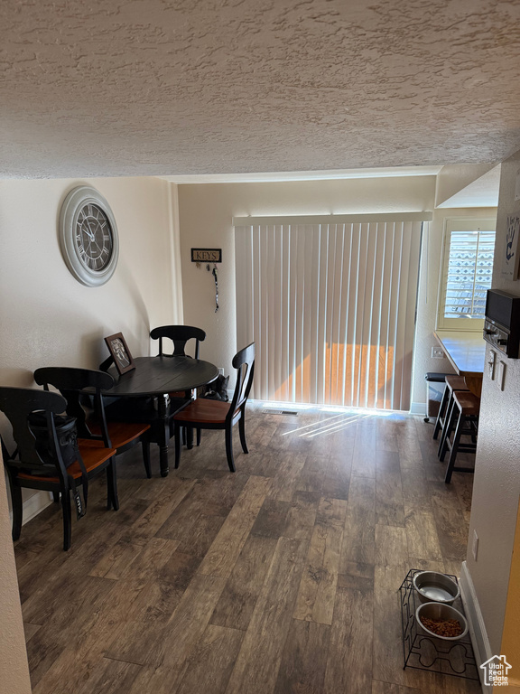 Dining area with wood finished floors and a textured ceiling