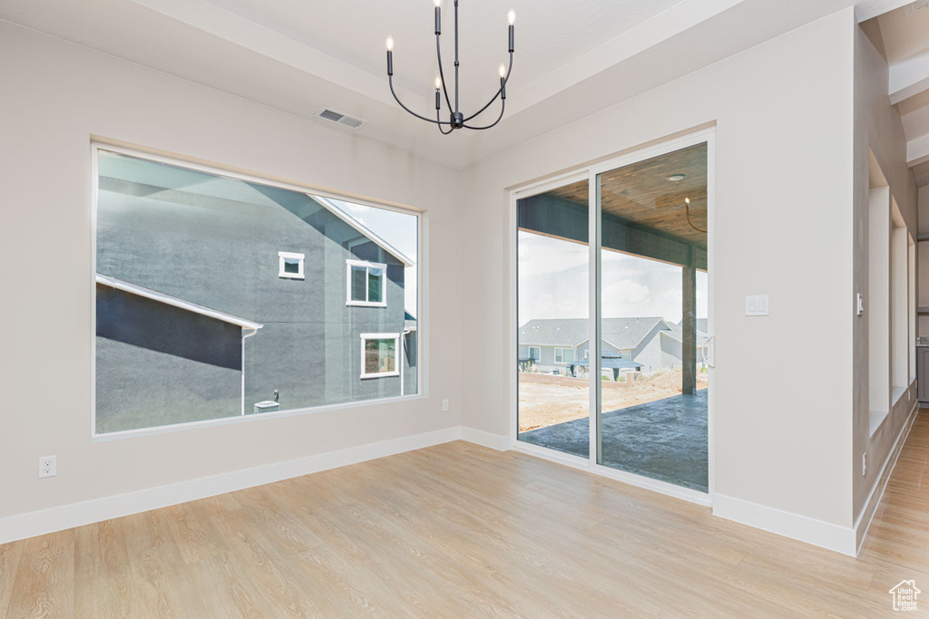 Empty room with a chandelier and wood finished floors