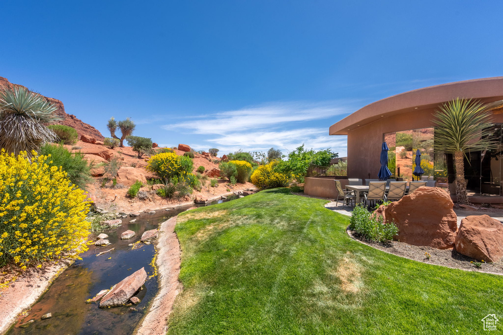 View of green lawn with a patio