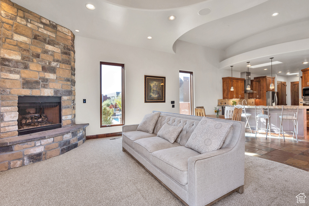 Living area with recessed lighting, carpet floors, arched walkways, a fireplace, and baseboards