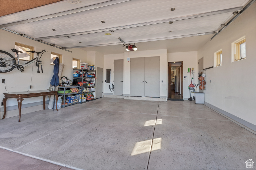 Garage featuring a garage door opener and baseboards