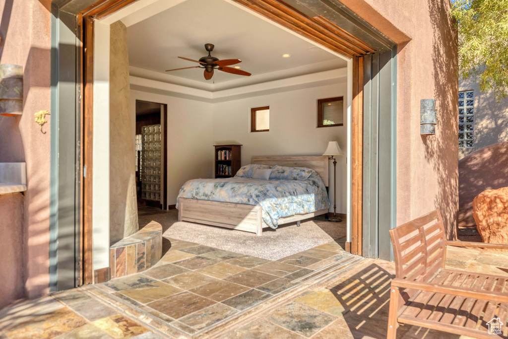 Bedroom featuring a raised ceiling and a ceiling fan