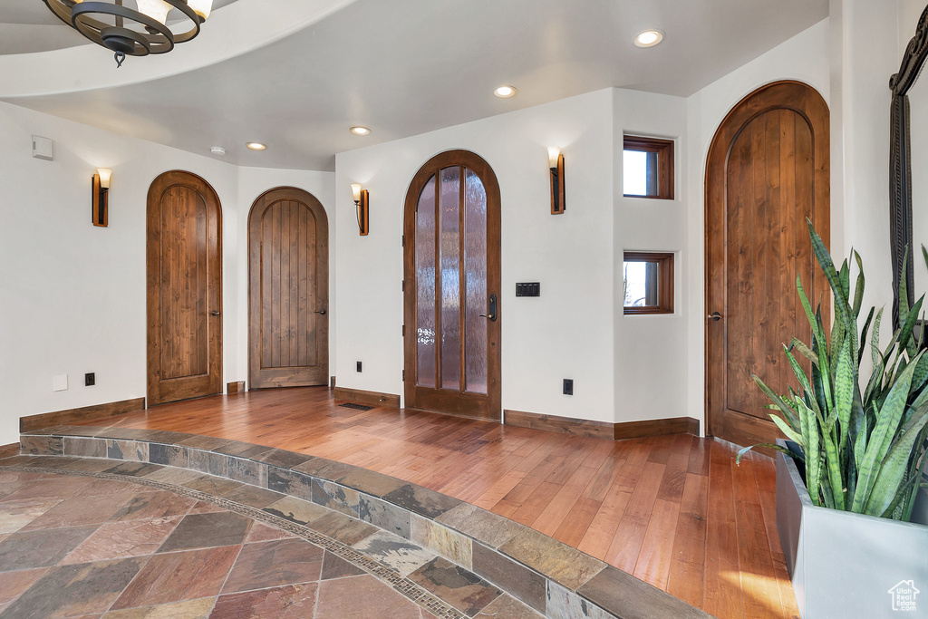 Foyer with arched walkways, recessed lighting, baseboards, and hardwood / wood-style flooring