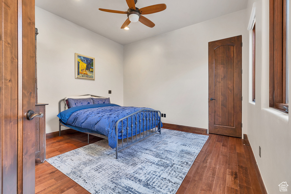 Bedroom with a ceiling fan, baseboards, and wood-type flooring