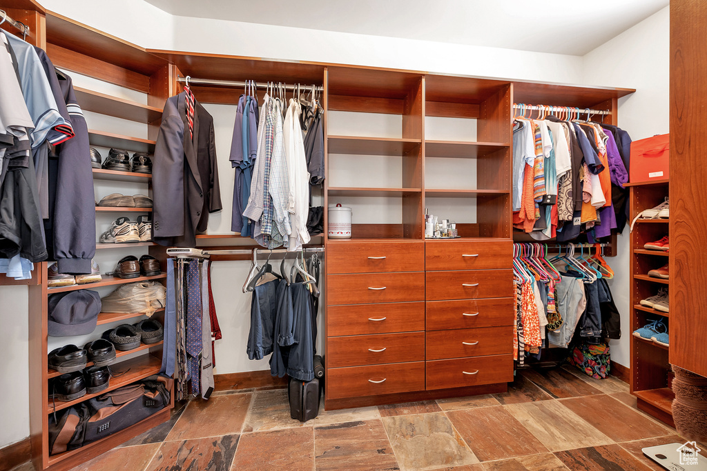 Walk in closet with stone tile flooring
