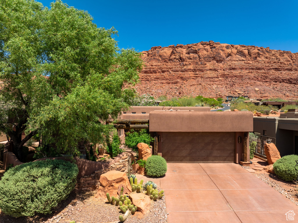 View of front of house with concrete driveway, stucco siding, and an attached garage