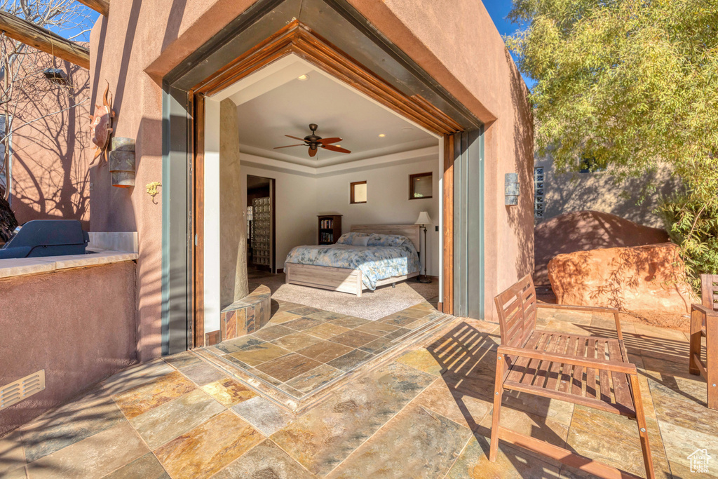 Bedroom with a raised ceiling and stone tile floors