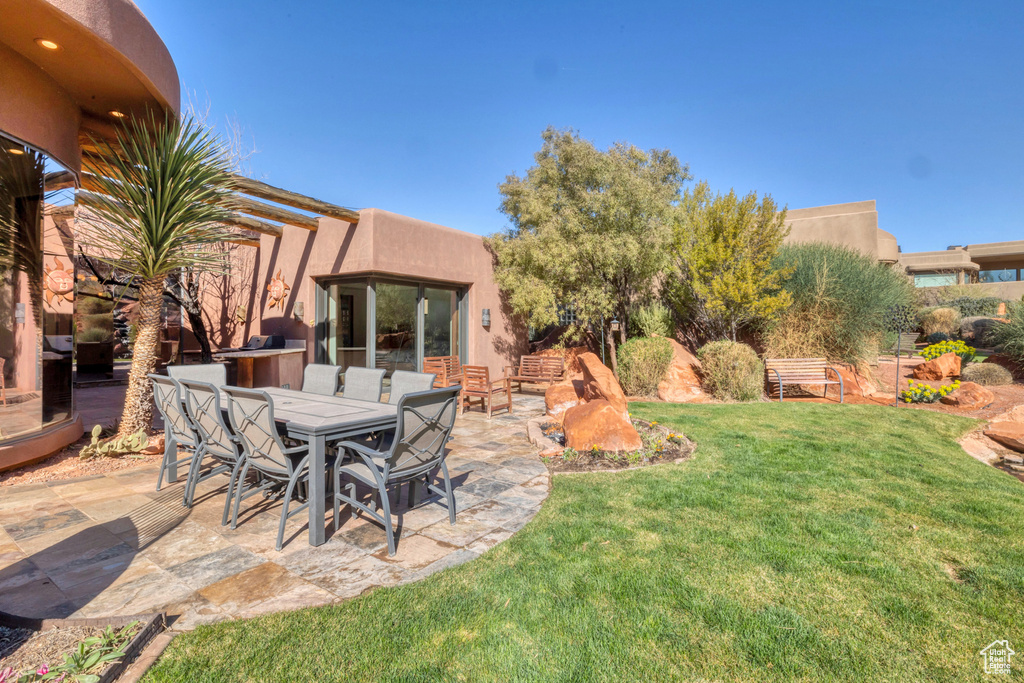 View of yard featuring outdoor dining area and a patio area