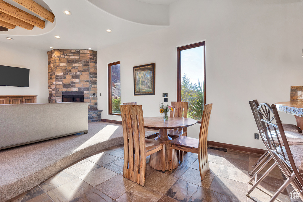 Dining room with recessed lighting, baseboards, stone tile floors, and a fireplace