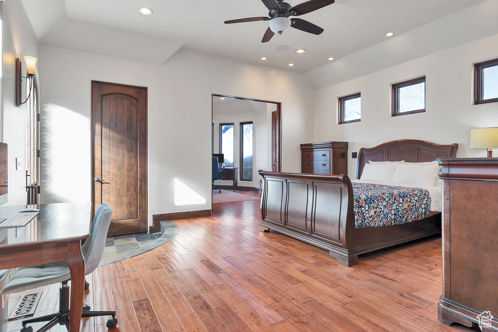 Bedroom with vaulted ceiling, recessed lighting, light wood-type flooring, and baseboards