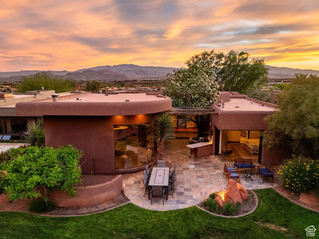 Rear view of property with stucco siding, a patio, a mountain view, and an outdoor living space
