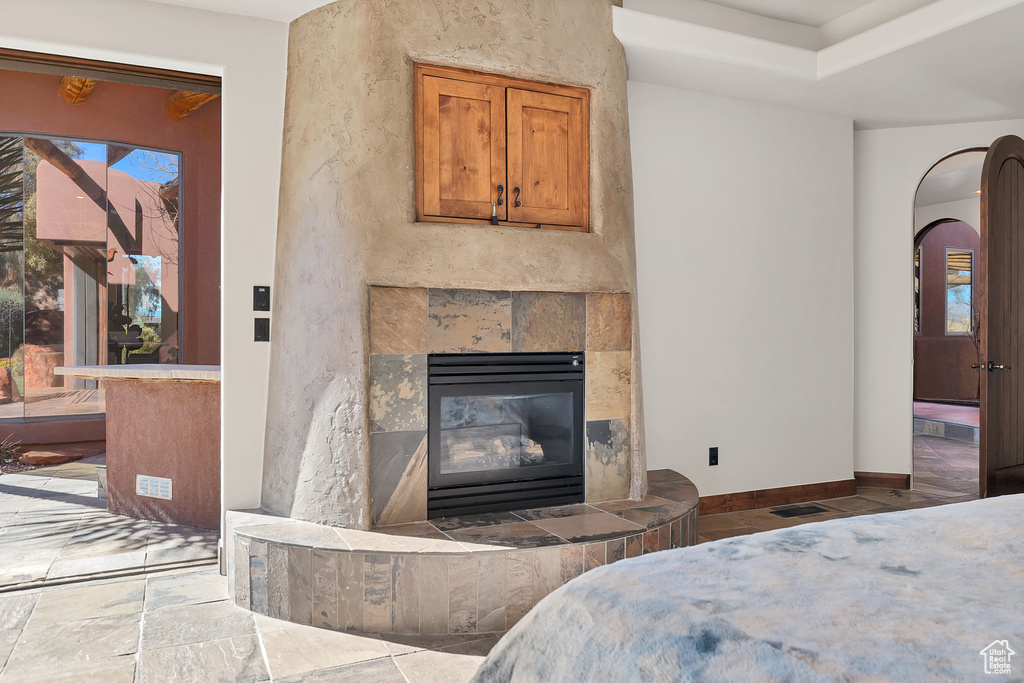 Bedroom with arched walkways, visible vents, a fireplace, and baseboards