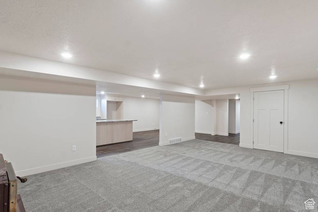 Finished basement featuring visible vents, recessed lighting, baseboards, and carpet floors