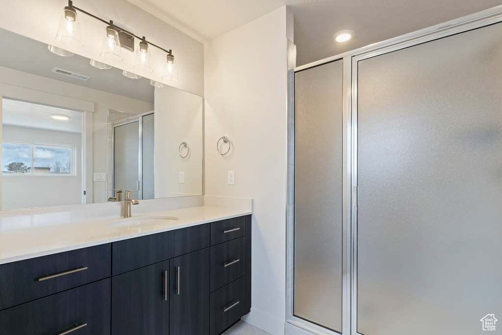 Bathroom featuring visible vents, recessed lighting, a stall shower, and vanity