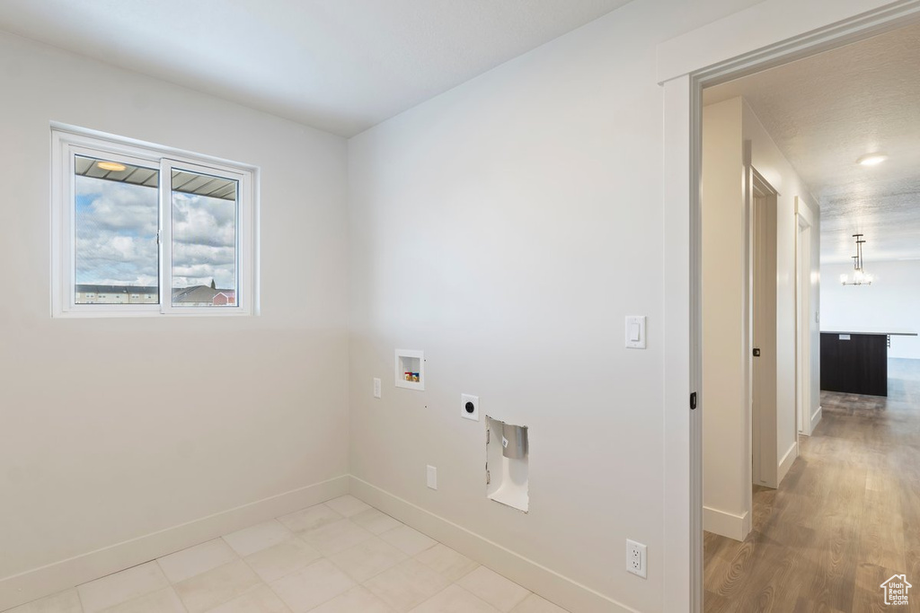 Laundry room with baseboards, hookup for an electric dryer, washer hookup, and laundry area