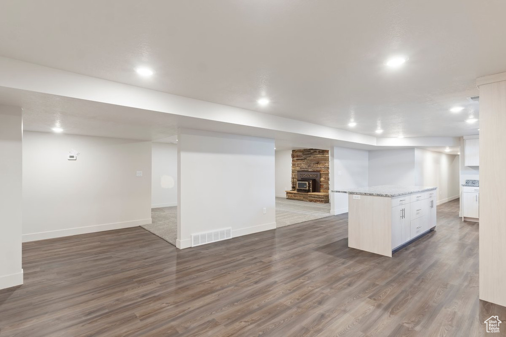 Finished basement with visible vents, wood finished floors, recessed lighting, a fireplace, and baseboards