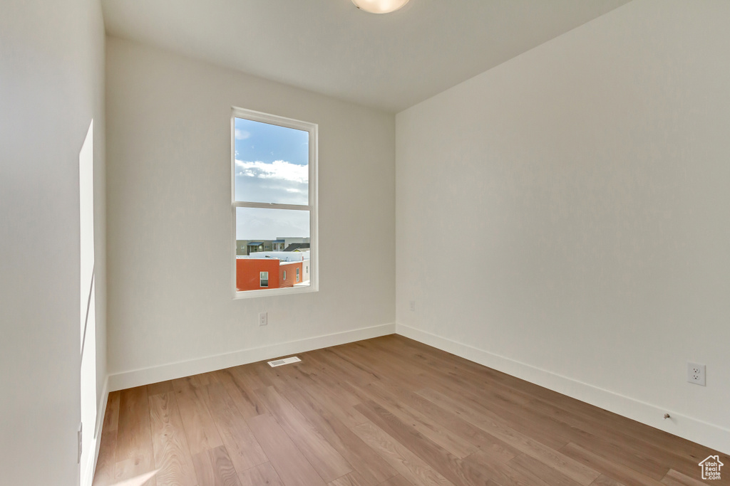 Empty room with visible vents, baseboards, and light wood-style floors