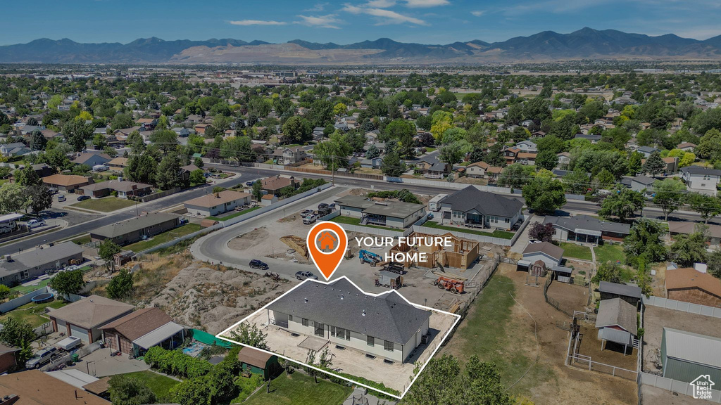 Aerial overview of property's location with property parcel outlined, a mountainous background, and nearby suburban area