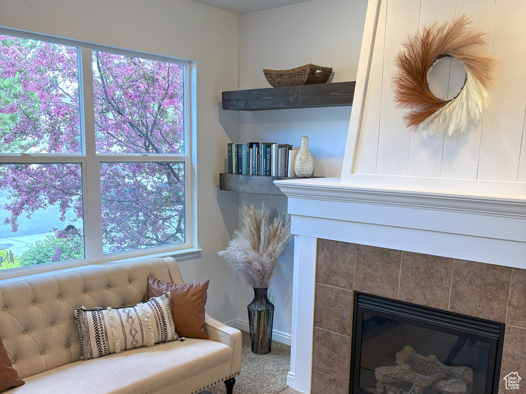 Detailed view of a tile fireplace, baseboards, and carpet