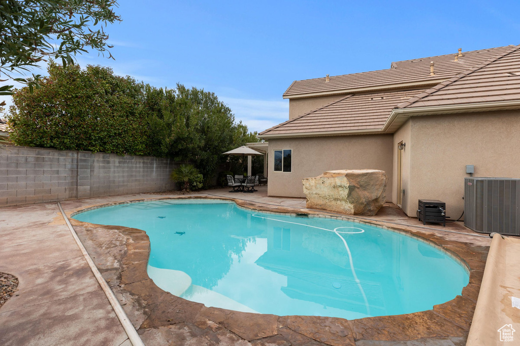View of swimming pool with a patio area, central air condition unit, a fenced in pool, and a fenced backyard