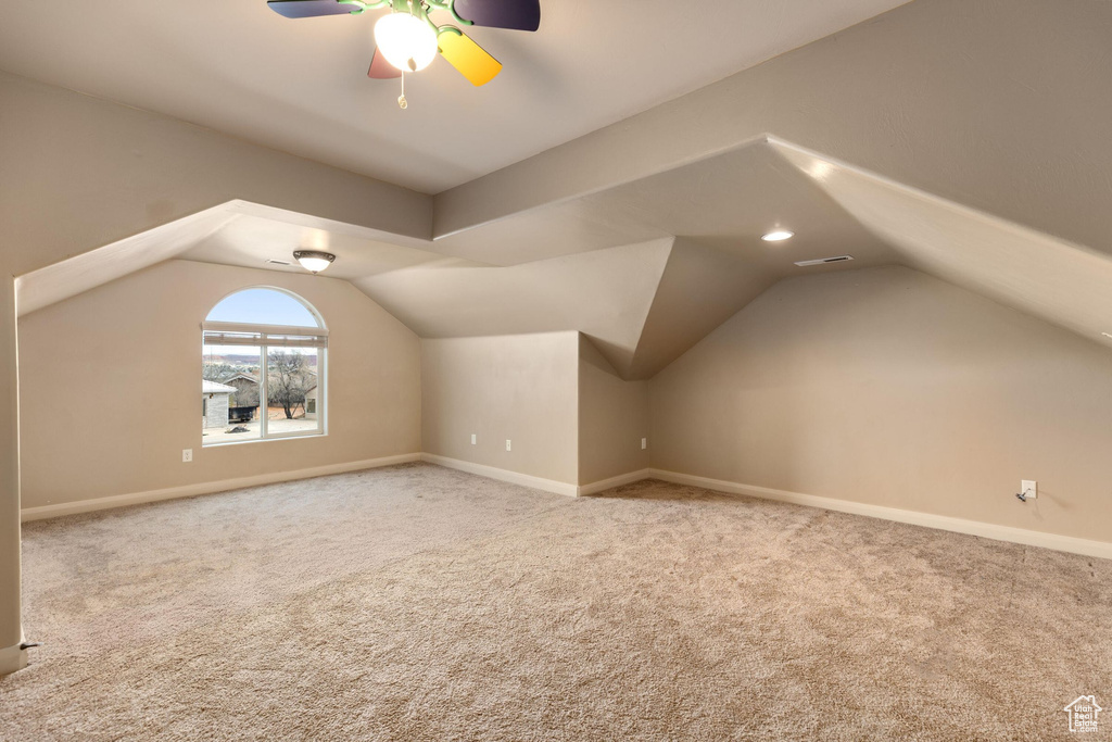 Bonus room with vaulted ceiling, carpet flooring, baseboards, and visible vents