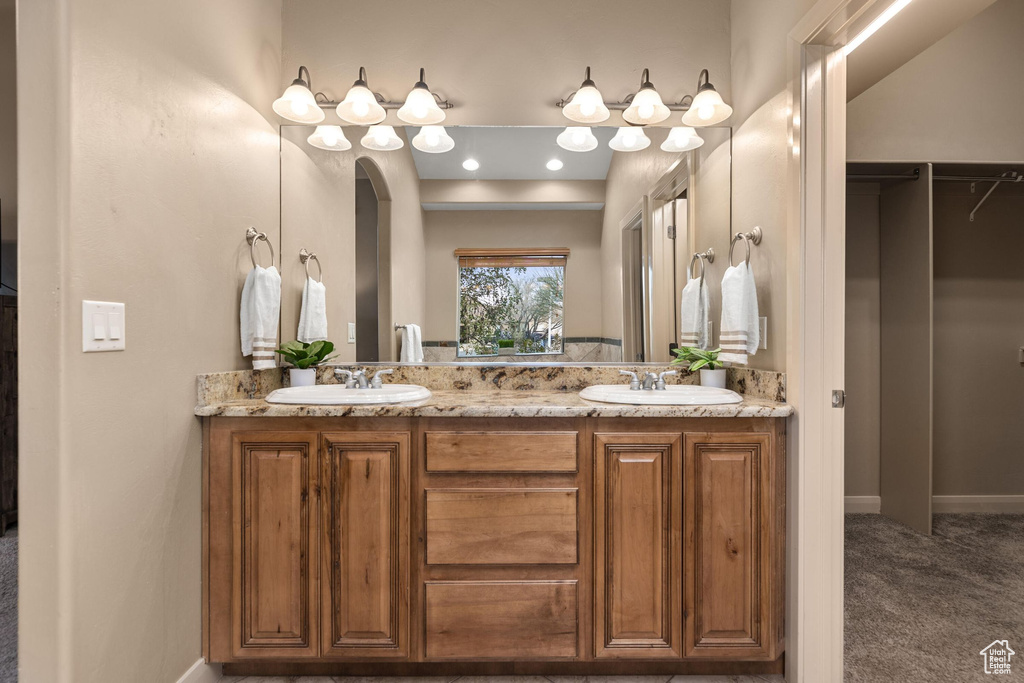Bathroom with double vanity, baseboards, and a sink